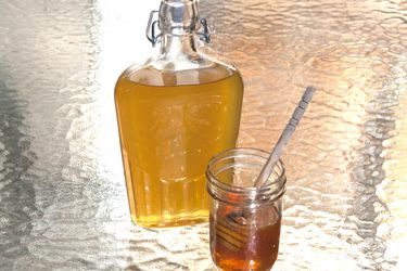 一瓶蜂蜜利口酒放在一罐蜂蜜旁边