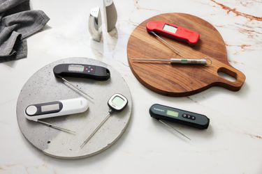 several kitchen thermometers on a marble countertop