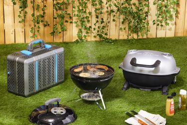 Three portable charcoal grills on a lawn