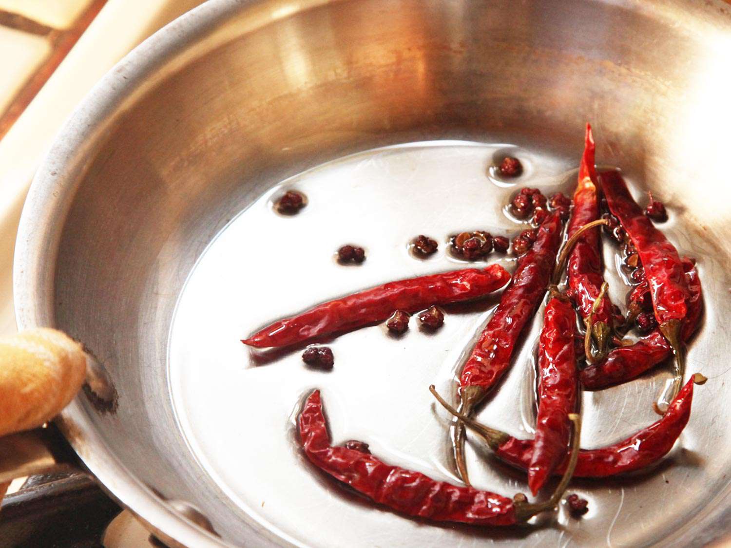 把干辣椒和花椒放在小煎锅里轻轻煎一下。