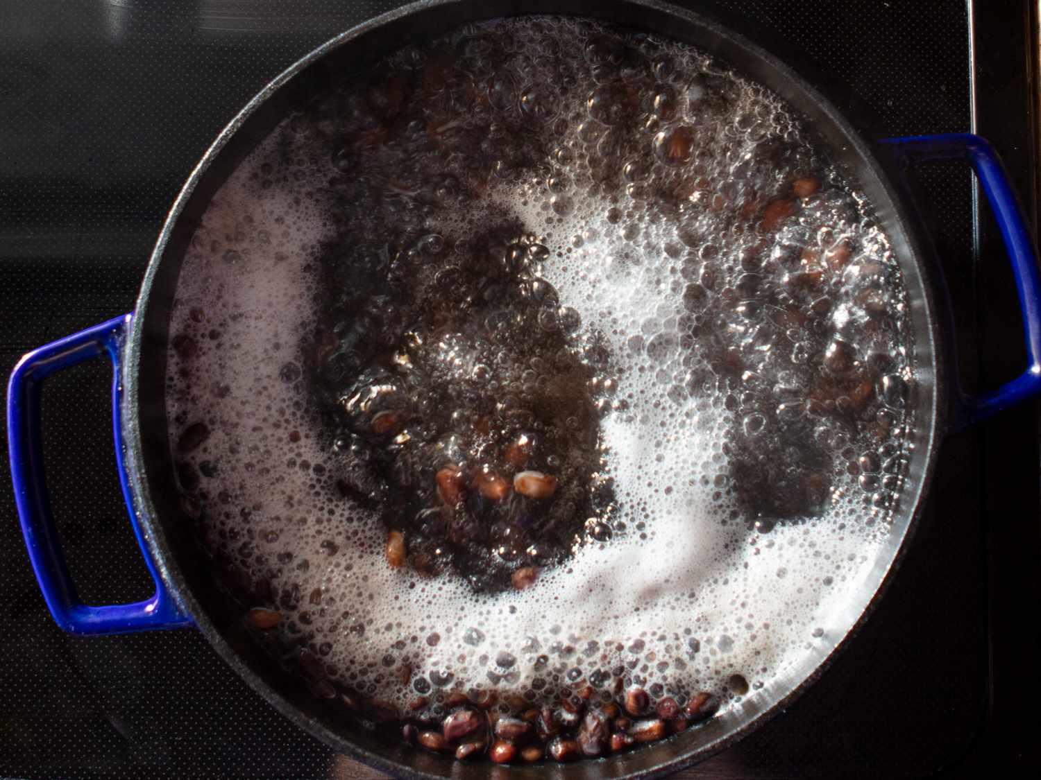 在荷兰烤箱的灶台上放入沸水中的Njahi豆gydF4y2Ba