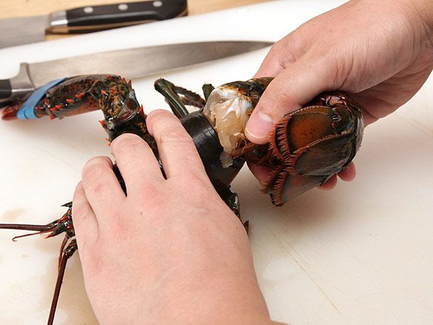 用另一只手抓着龙虾的甲壳，扭断龙虾的尾巴