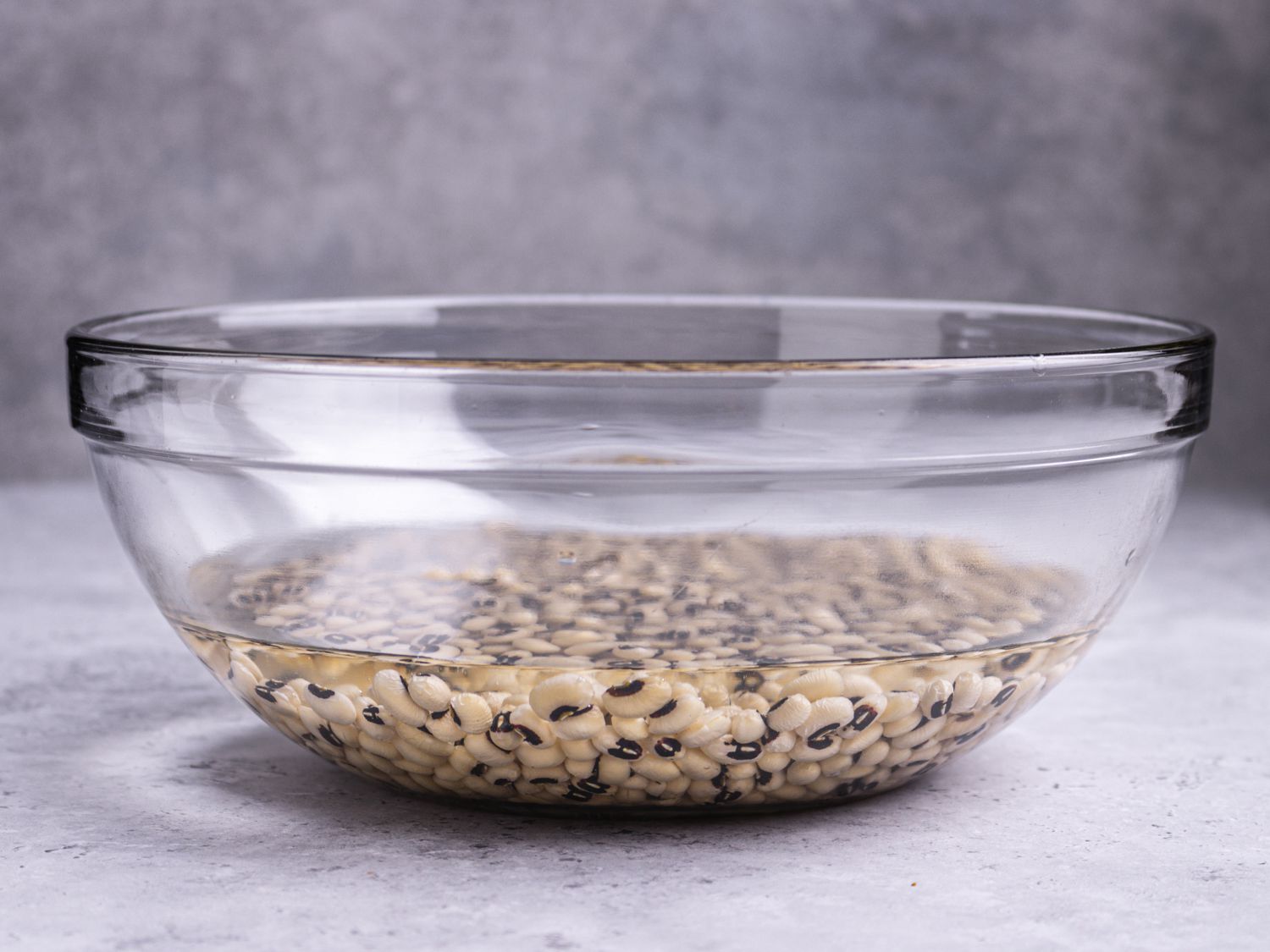 豌豆浸泡在一个装满水的玻璃碗的底部