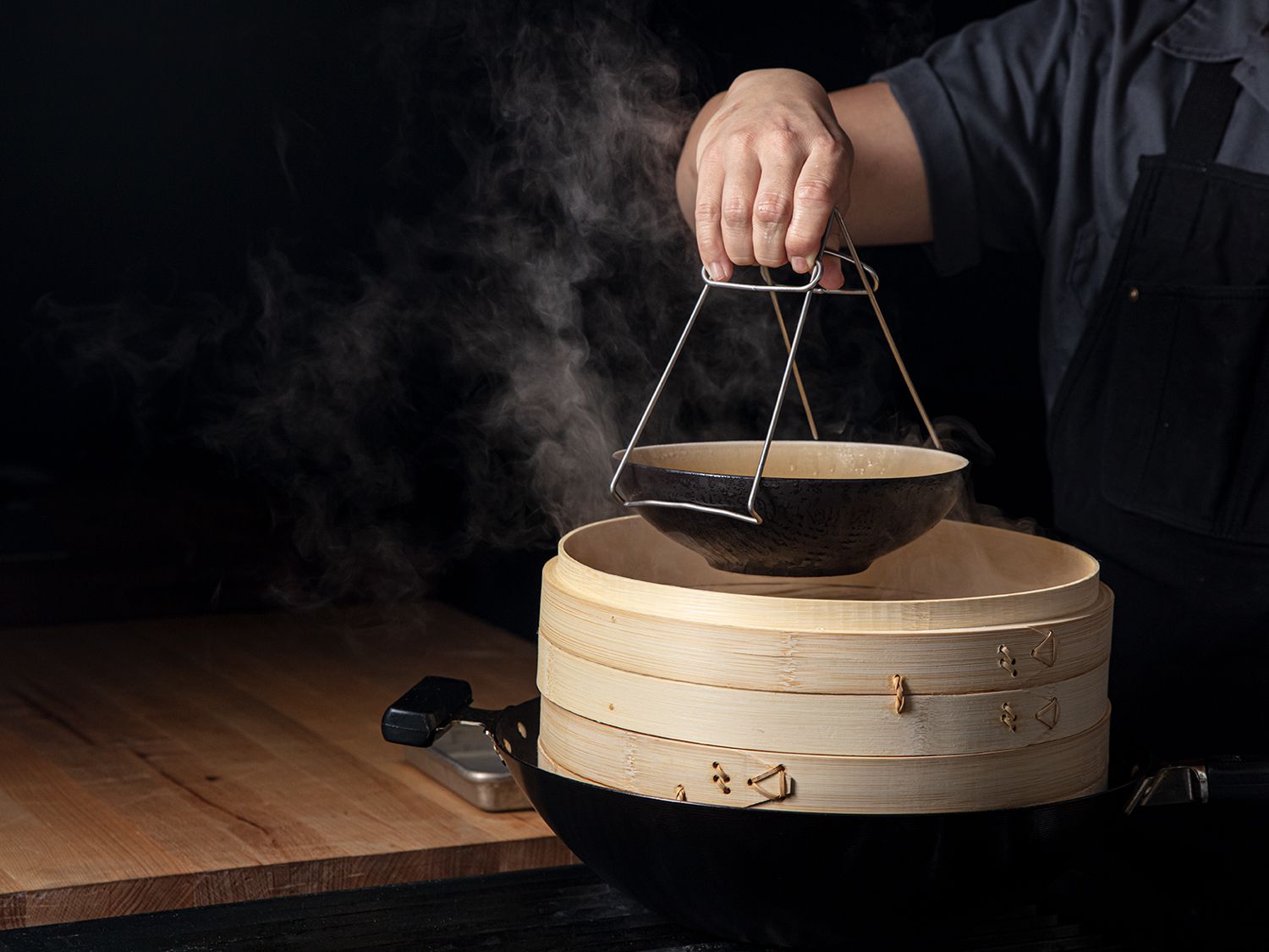 热菜蒸锅是把碗从放在锅里的竹蒸锅里提出来。