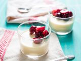 Glass cups filled with vanilla panna cotta and fresh cherries