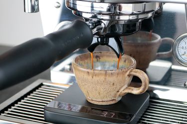 an espresso shot flowing off of the dual spouts into a cup