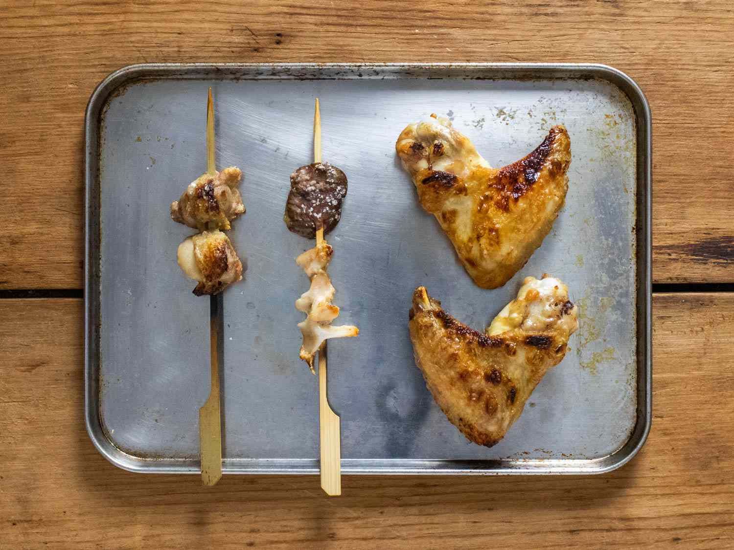鸡牡蛎、心脏、胸部软骨和翅膀烤边的烤盘上