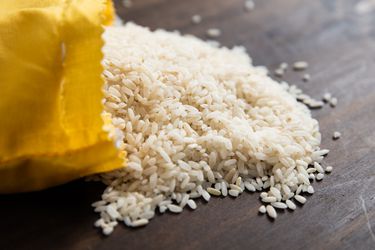 卡罗莱纳金黄色的大米从纸袋里溢出来，放在木柜台上。