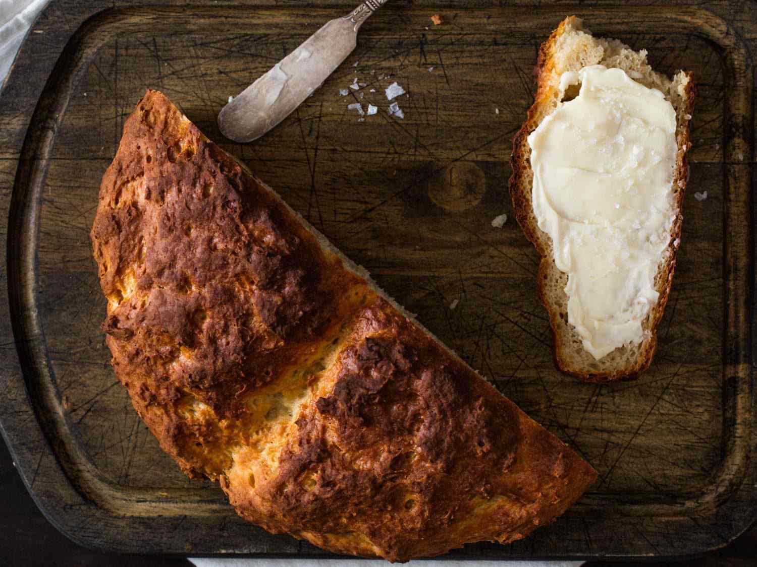 开销的一半爱尔兰苏打面包一块木板,旁边一片面包涂有黄油