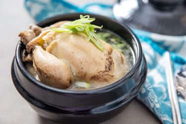 一碗samgyetang,整个挖走了康沃尔郡的母鸡,汤,和新鲜的青葱浇头