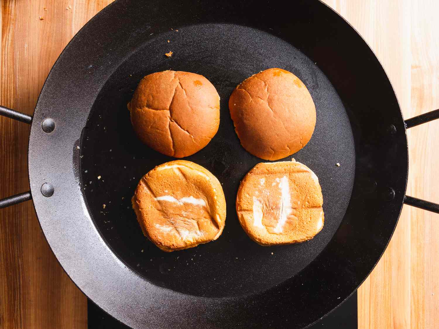 hamburger buns toasting in a skillet
