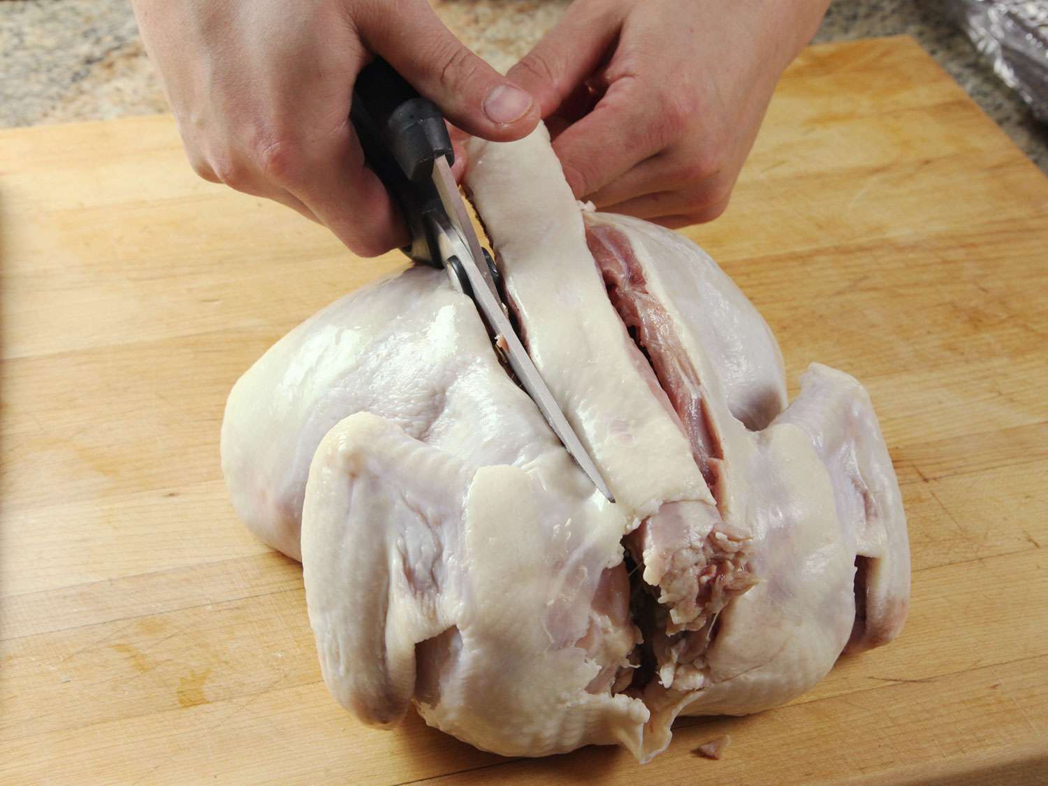 用家禽剪去生鸡肉的脊骨