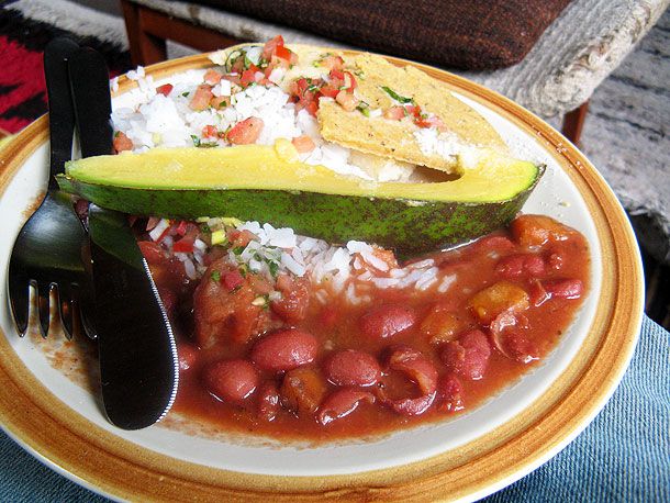 哥伦比亚风味的豆子和米饭，bandeja paisa，配aji(哥伦比亚风味的莎莎酱)和牛油果楔形。