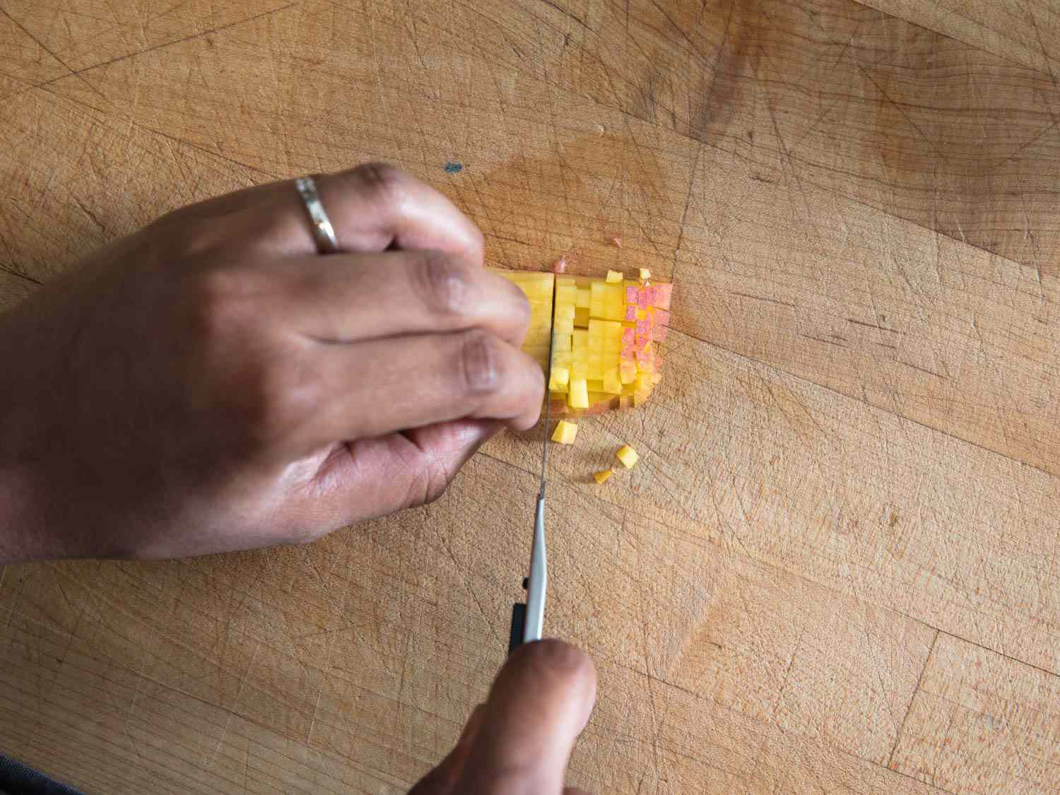 用美工刀在木砧板上切苹果