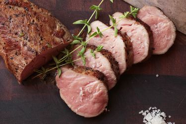 Sliced sous vide pork tenderloin cooked medium rare and seared to form browned exterior.
