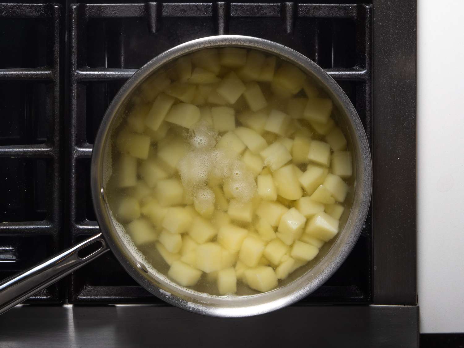 在炉子上的锅里煮土豆块。