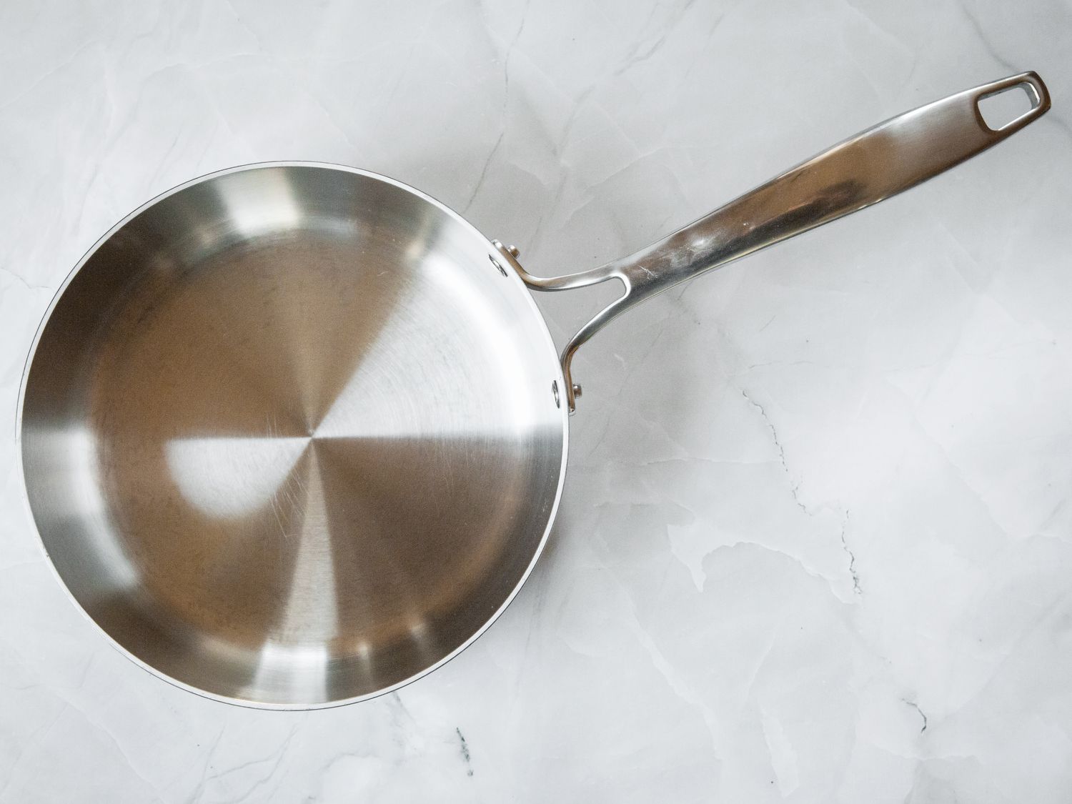 A stainless steel saucepan on a marble surface