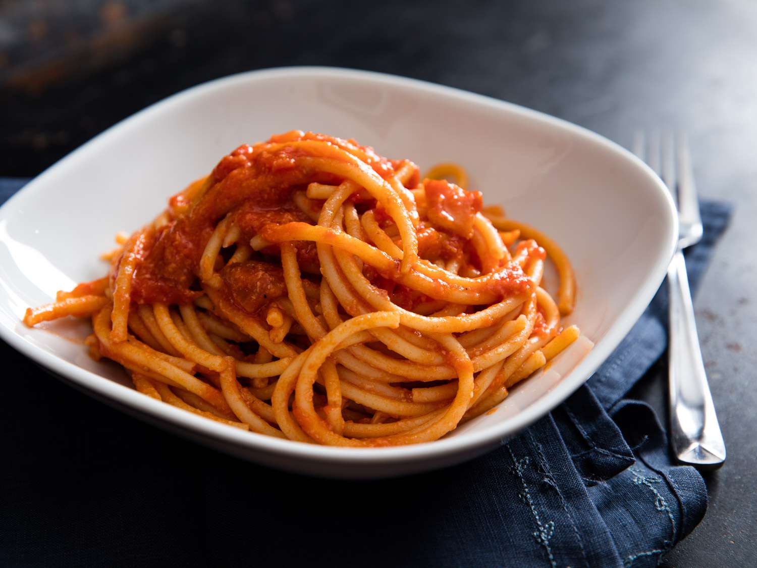 A white bowl full of bucatini all'amatriciana