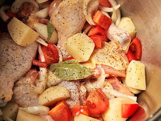 调味鸡,土豆,西红柿,和洋葱混合在一个碗里。