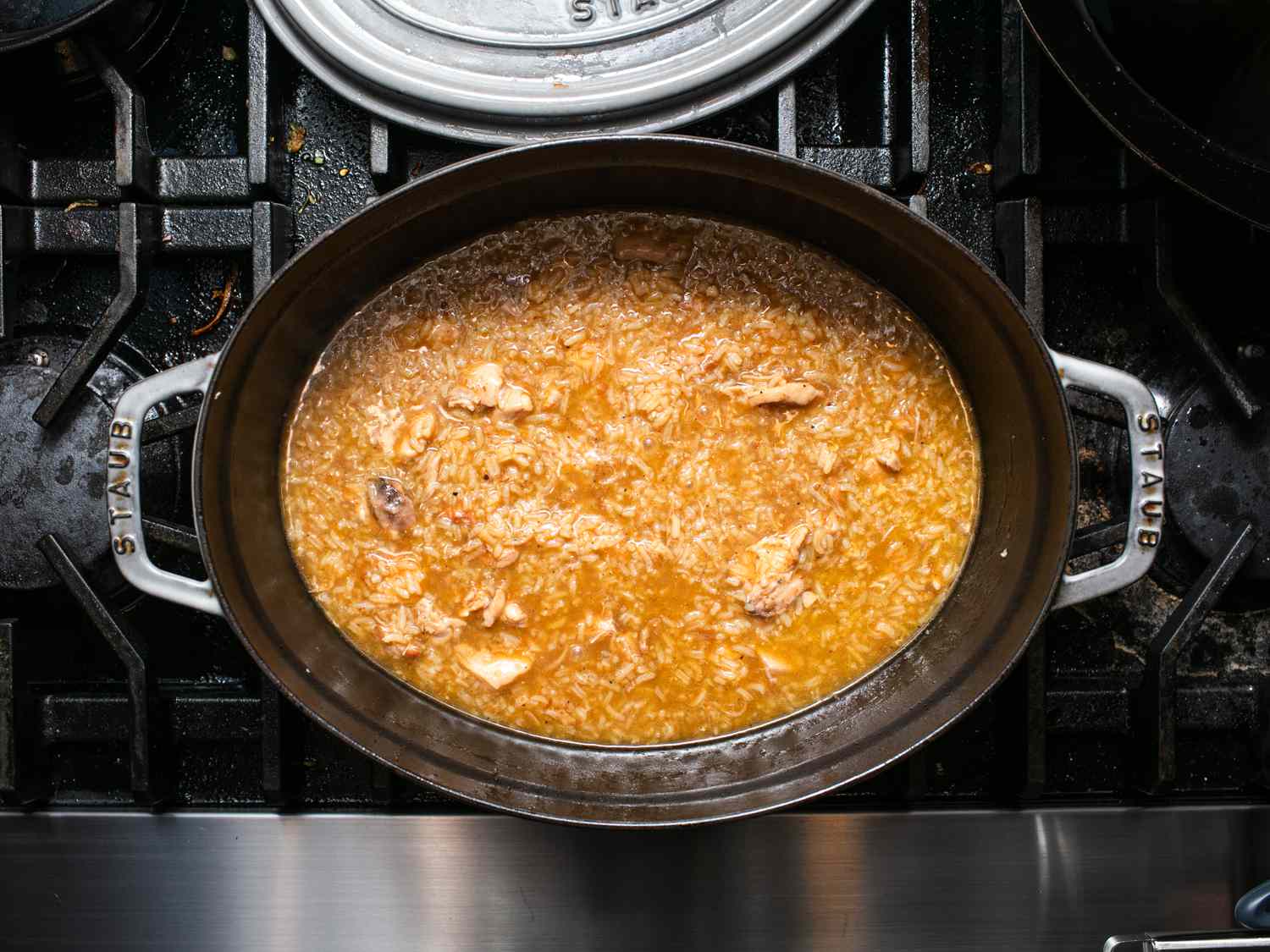 吃Arroz caldo后添加了大米和煮熟的炉灶。