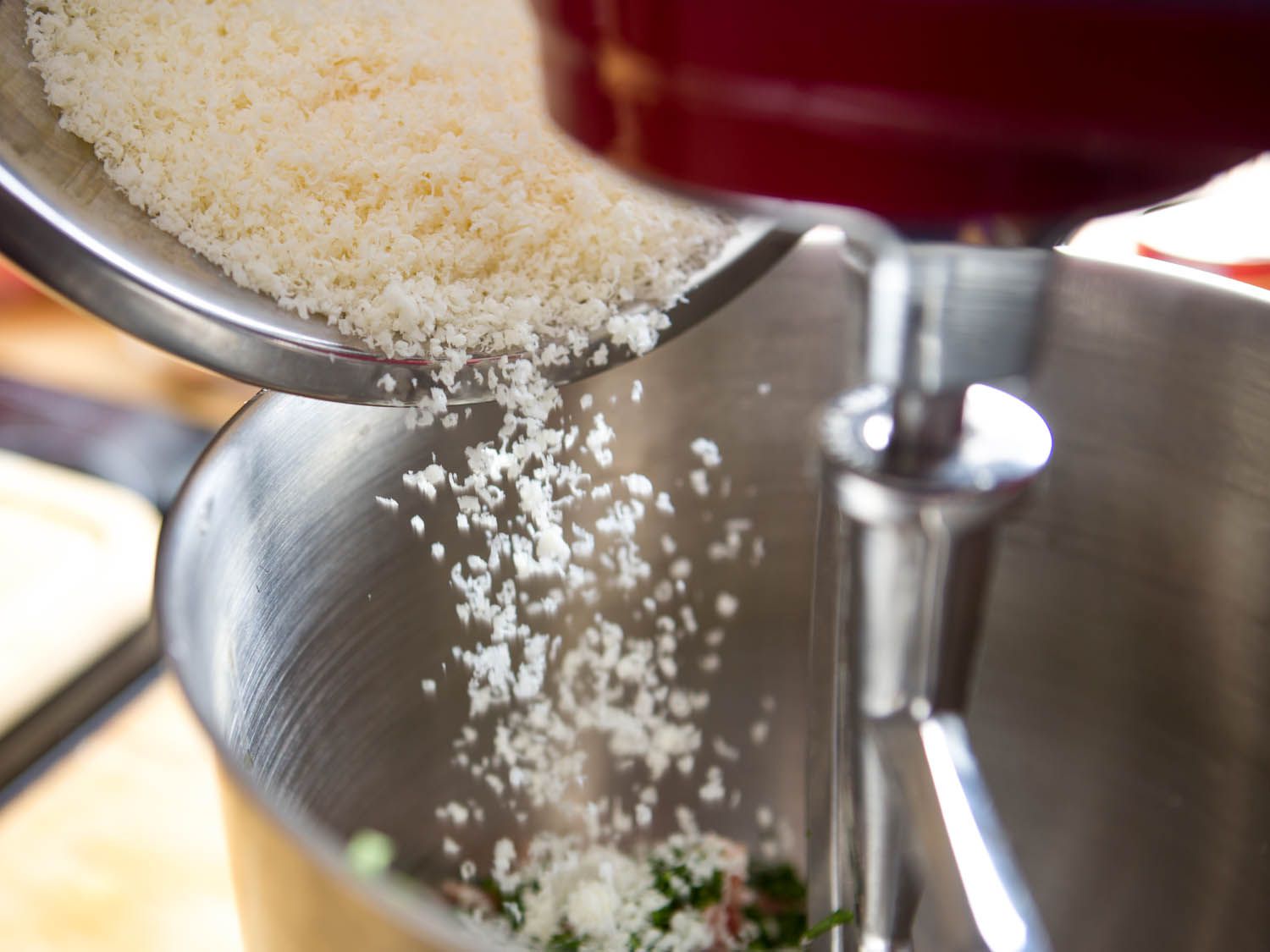加入刚磨碎的帕玛森干酪到一碗肉丸搅拌器中。