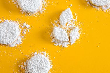 黄色背景上覆盖着糖粉的柠檬融化饼干
