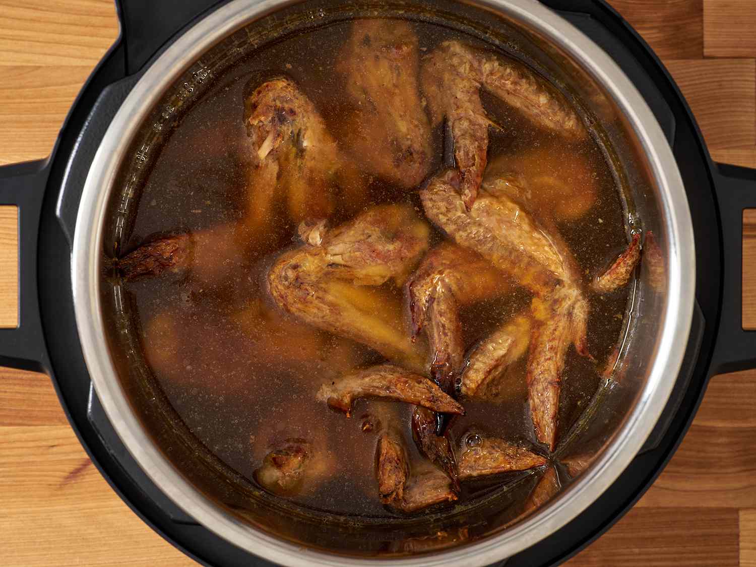 把鸡翅和水放在高压锅里。