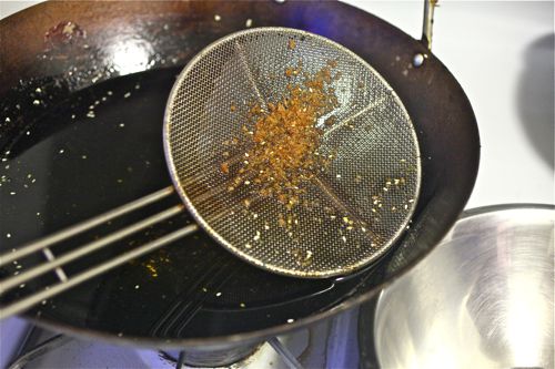 在炒锅里滤出煎油残渣。