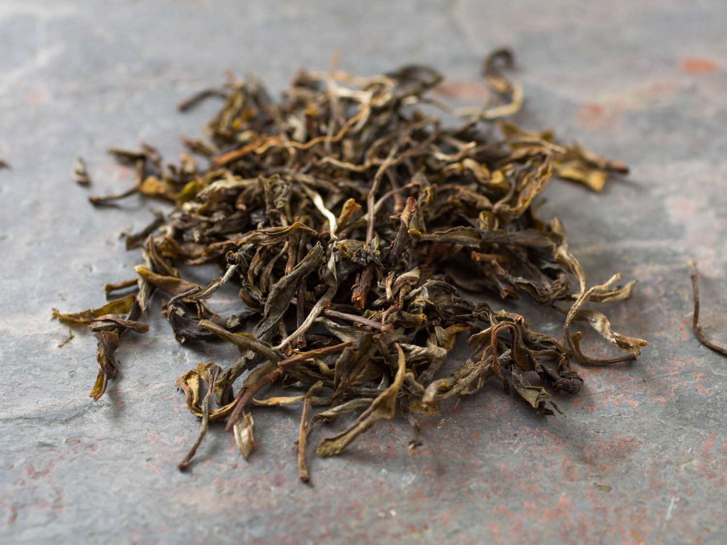 一堆松散的普洱茶茶叶从翠绿的茶