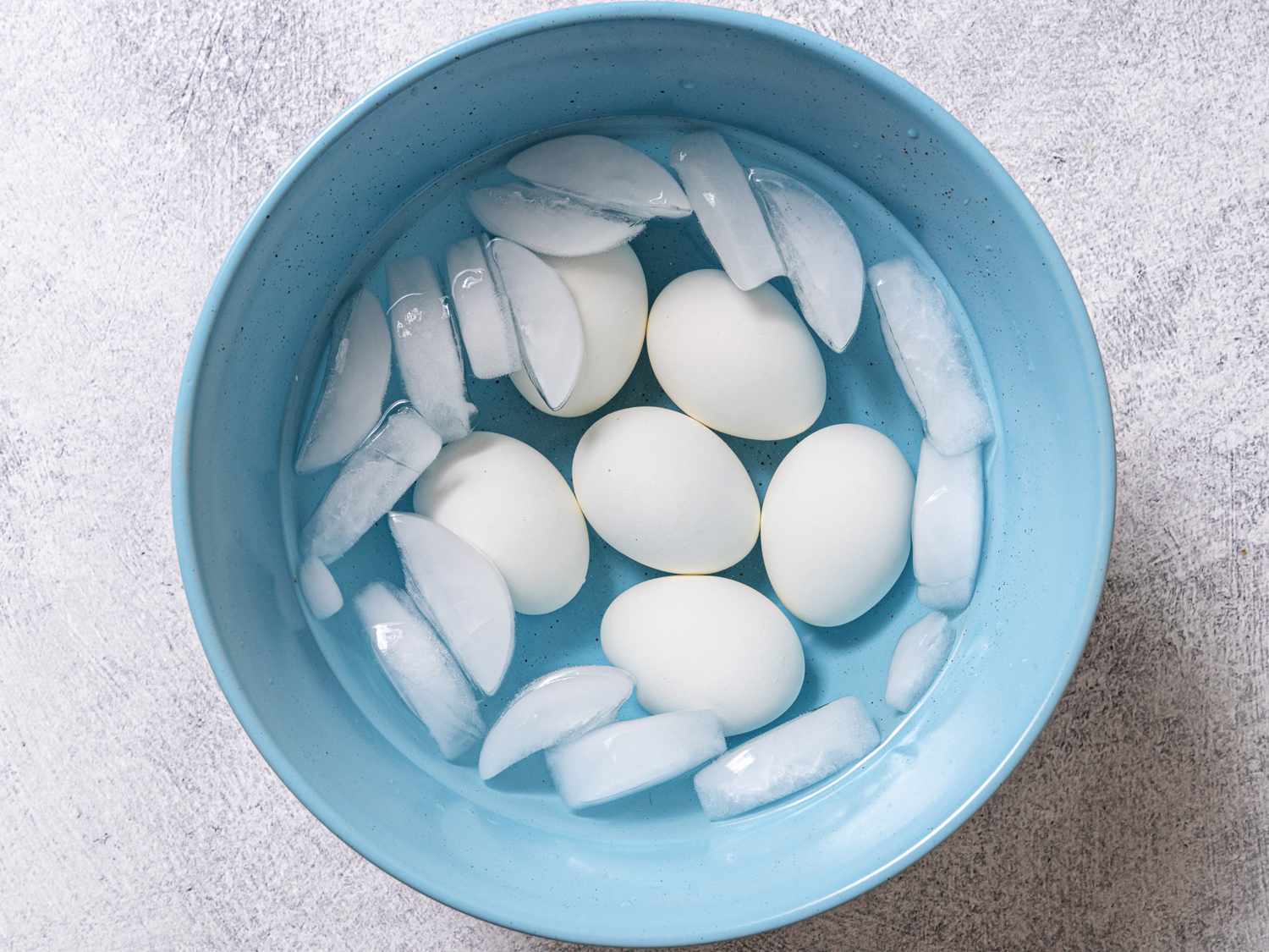 把蒸熟的鸡蛋放在装有冰浴的蓝碗里。