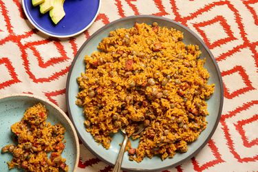 Overhead view of arroz con gandules on a red patterned background