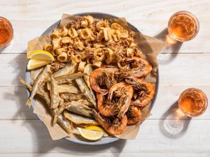 A large platter of fritto misto di mare with fried shrimp, squid, and smelt.