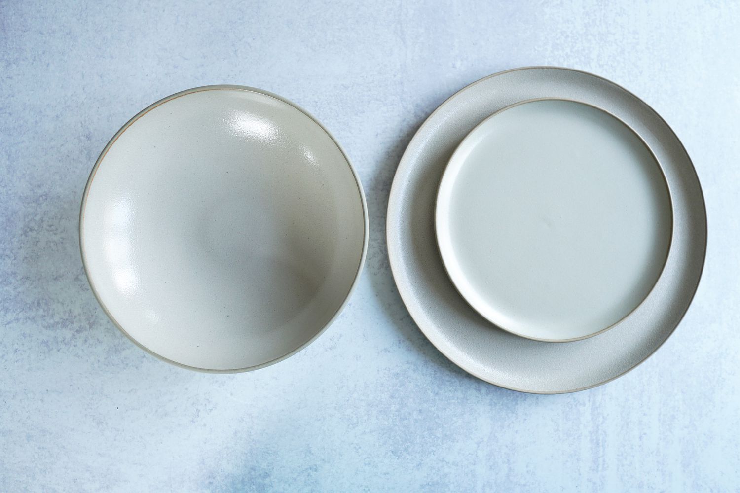 a white and brown dinnerware set on a grey surface