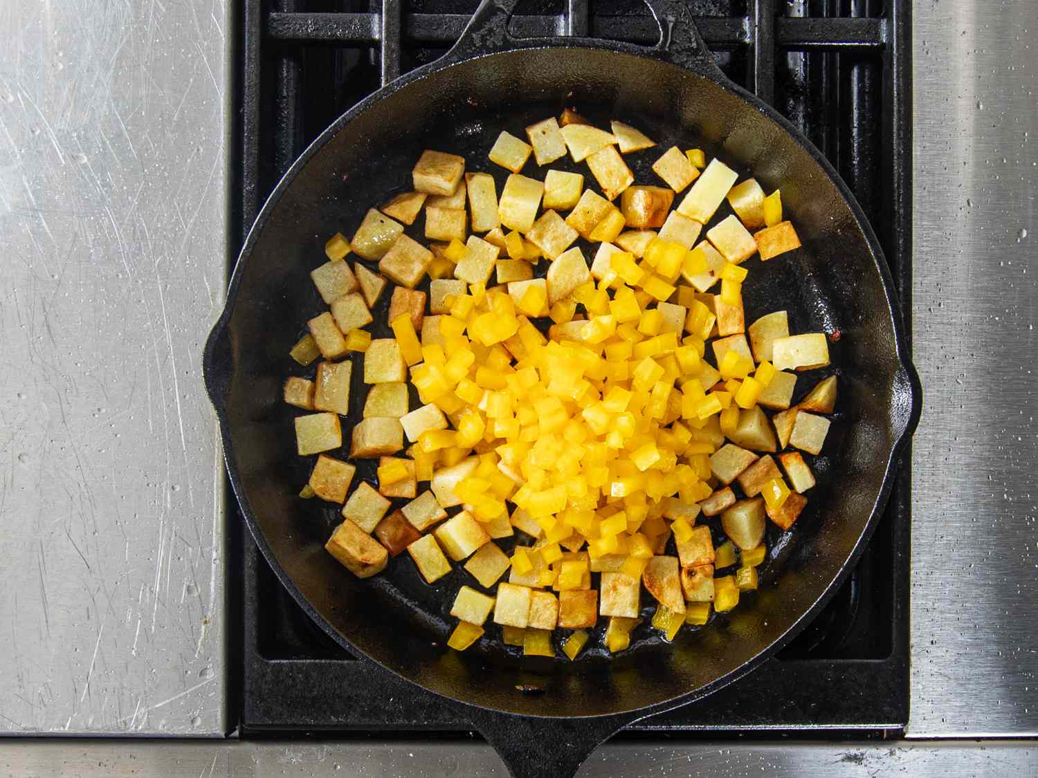 在煎锅里把辣椒加到土豆里。
