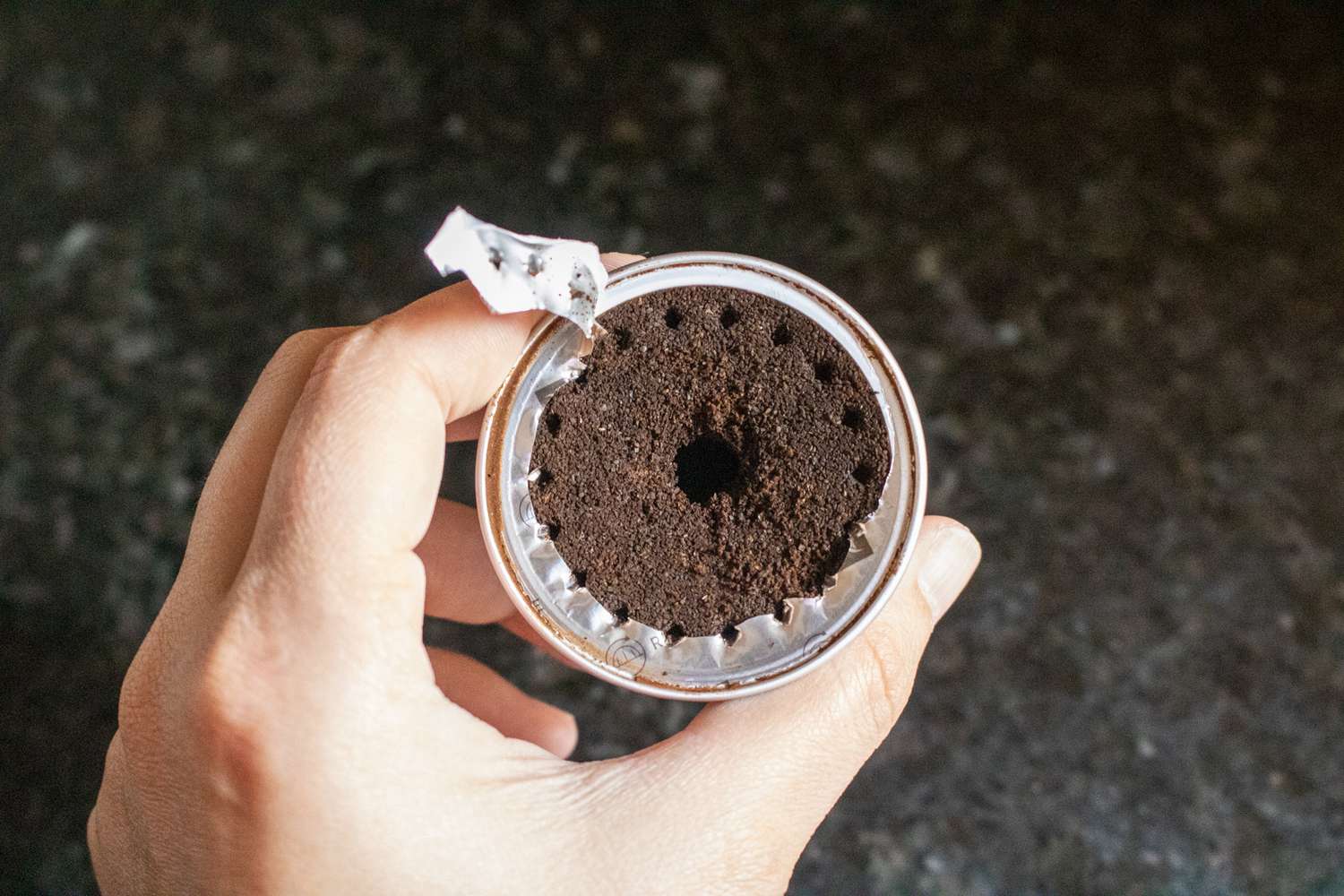 一个用过的Nespresso胶囊的俯拍，去掉了锡纸的顶部，这样你就可以看到咖啡渣了