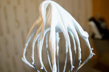 白色意大利蛋白霜在厨房辅助搅拌机搅拌附件
