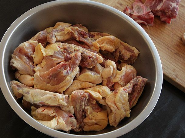 盛有制作高级肉汤的鸡肉部分的大搅拌碗。