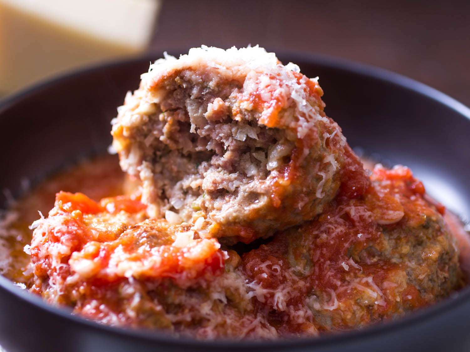 在一个深色的碗里吃一个意大利美式肉丸。