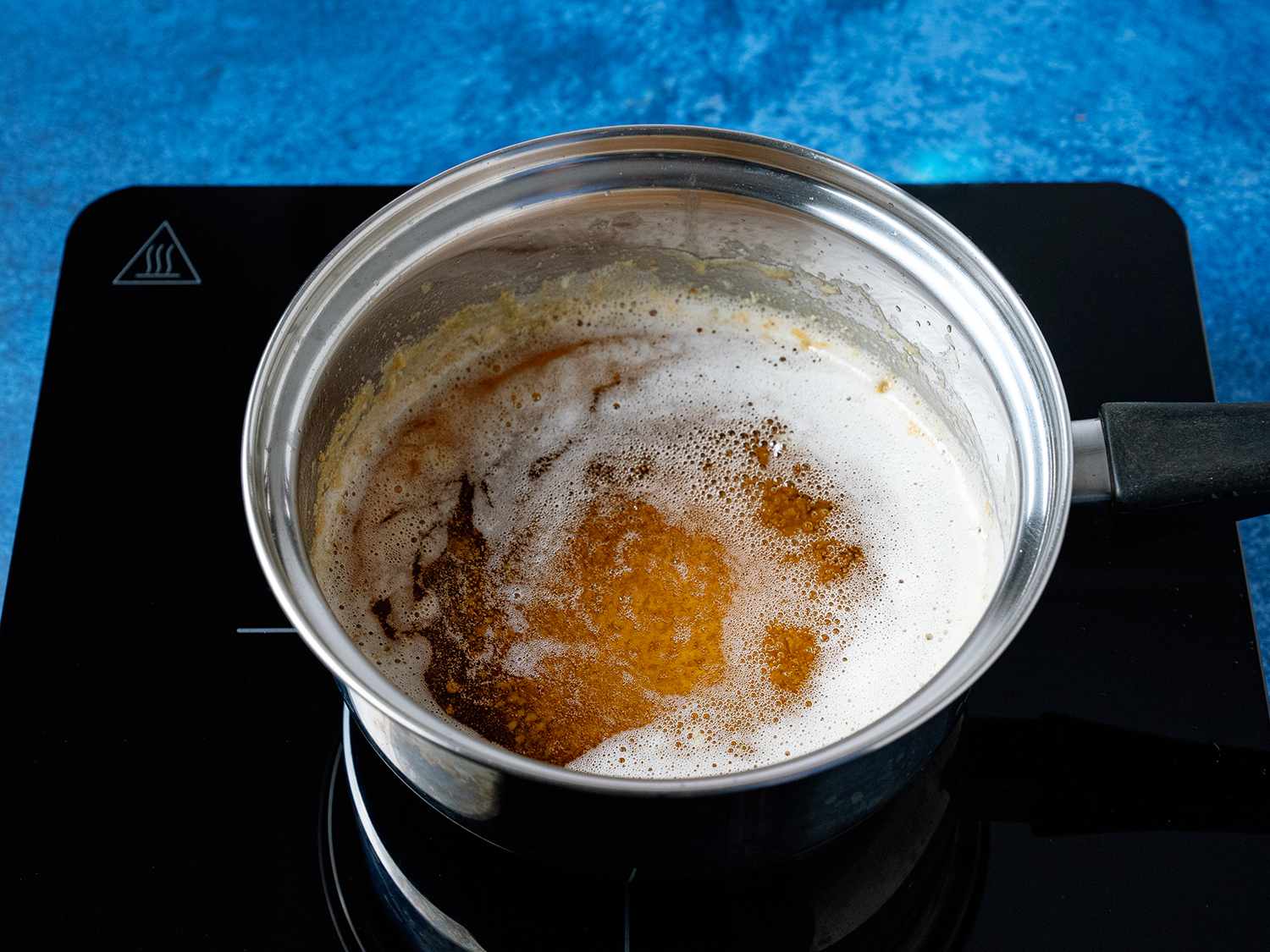 一锅沸腾的黄油和牛奶蛋白下沉到锅底