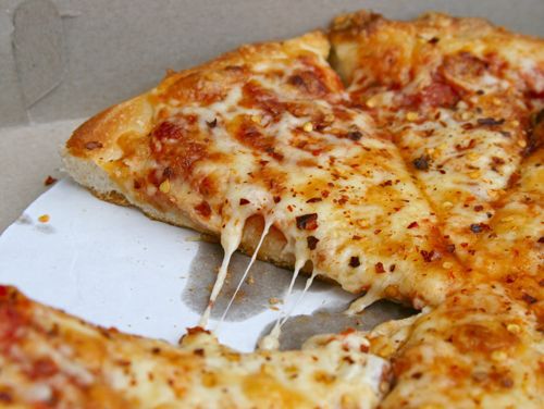 薄皮披萨，上面覆盖着奶酪和红辣椒片。gydF4y2Ba
