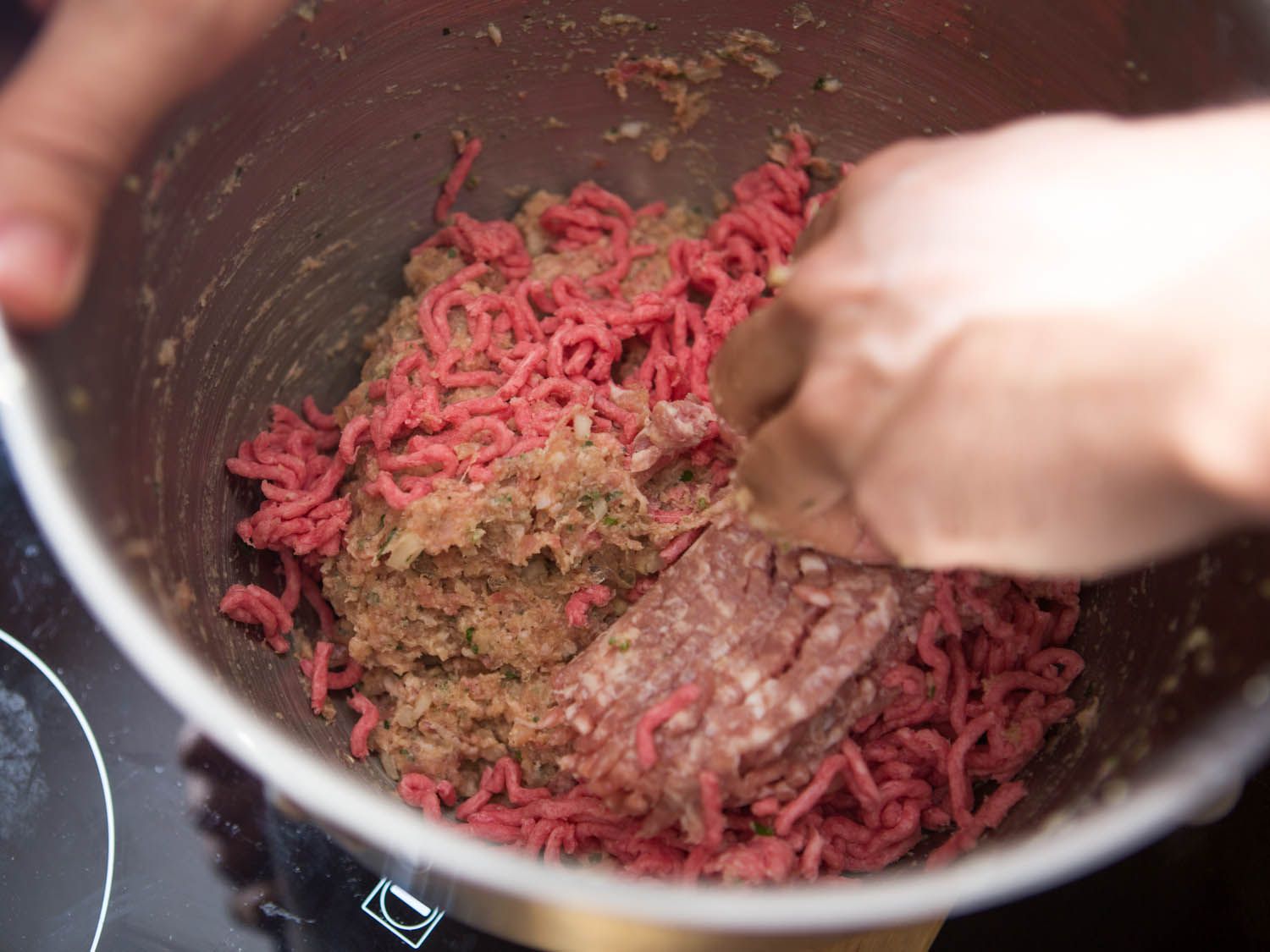 用手将肉末搅拌成乳化肉和调味料混合制成肉丸。