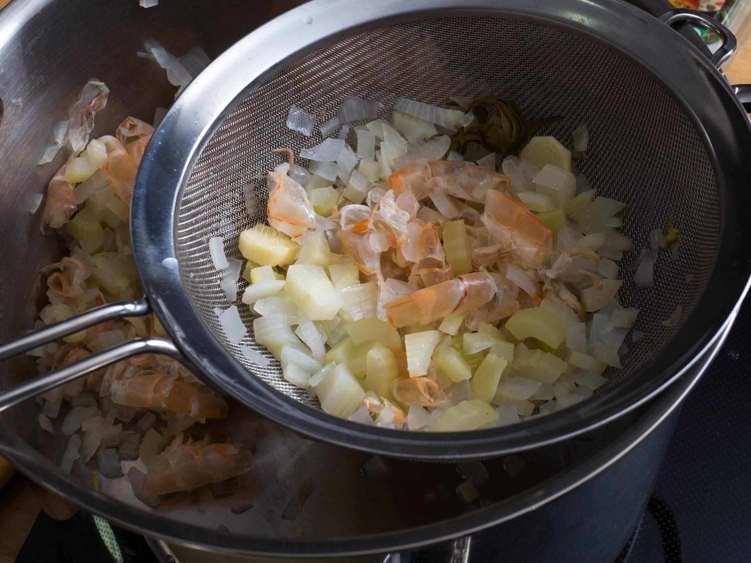 虾壳和肉汤中的其他固体物用小过滤器从锅中去除。gydF4y2Ba