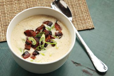 A bowl of easy-to-make creamy cauliflower soup garnished with bacon