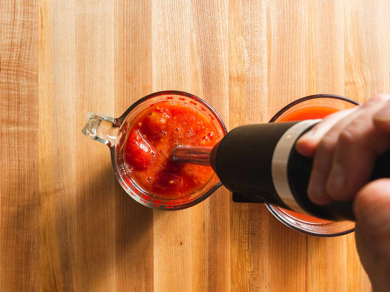 用浸入式搅拌机搅拌罐装去皮西红柿