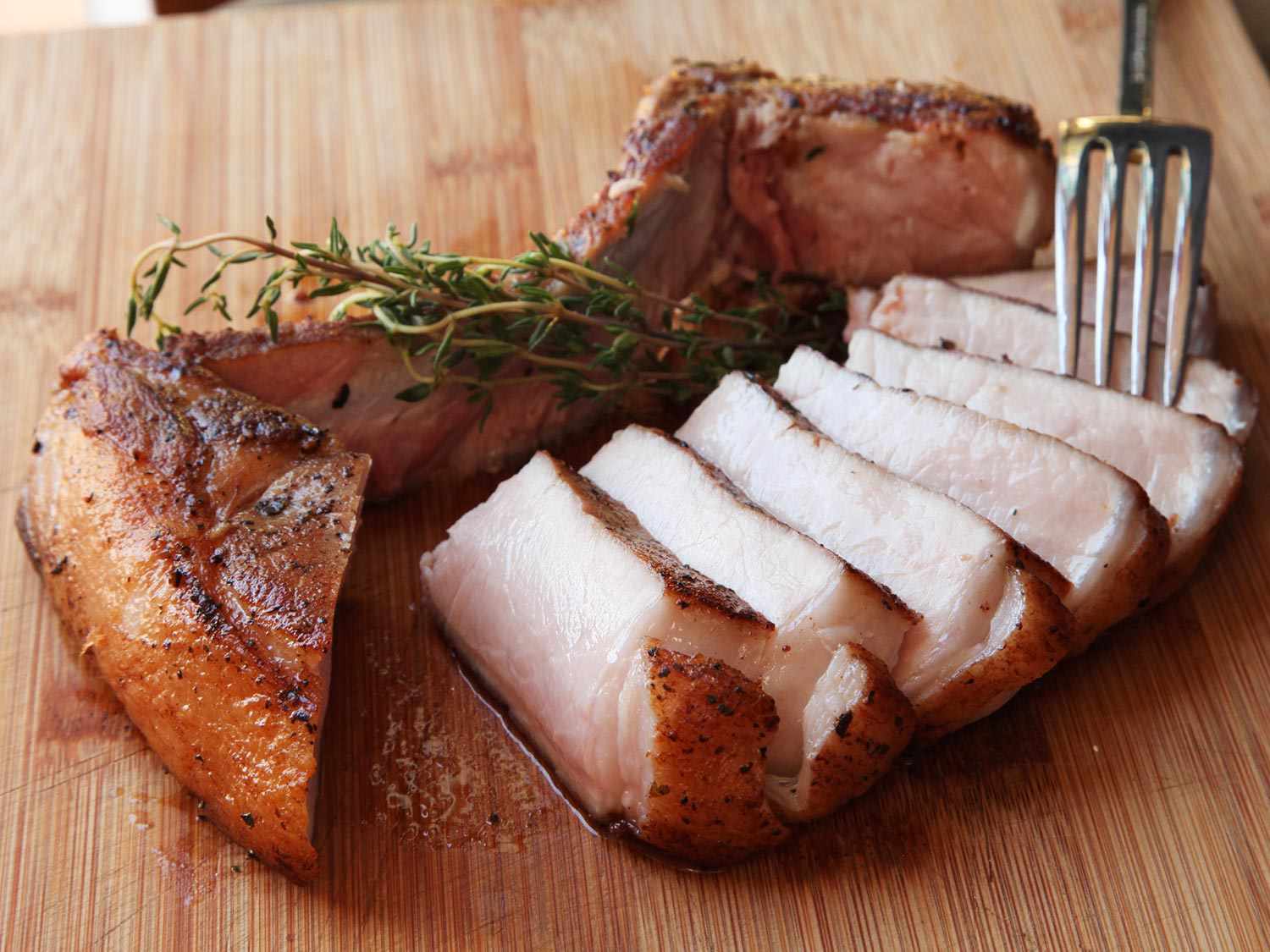 Sliced sous vide pork chops on a cutting board.