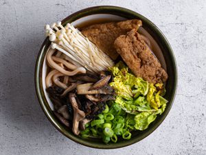 日本乌冬面放在陶瓷碗里，配上蘑菇-大豆汤，炒蘑菇，生蘑菇，葱花，卷心菜和豆腐。