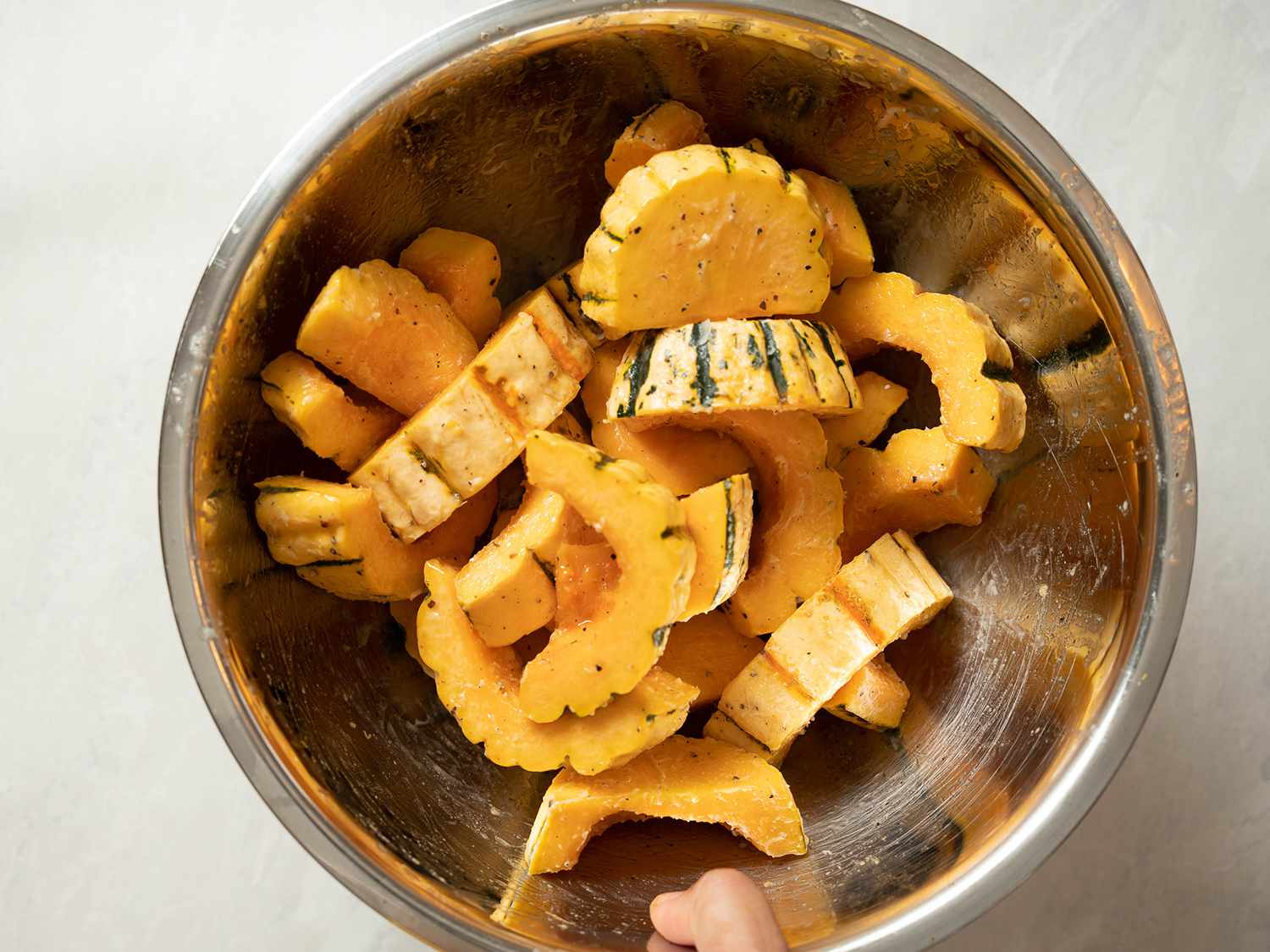 片的红薯南瓜扔黄油,盐和胡椒混合在一个碗里