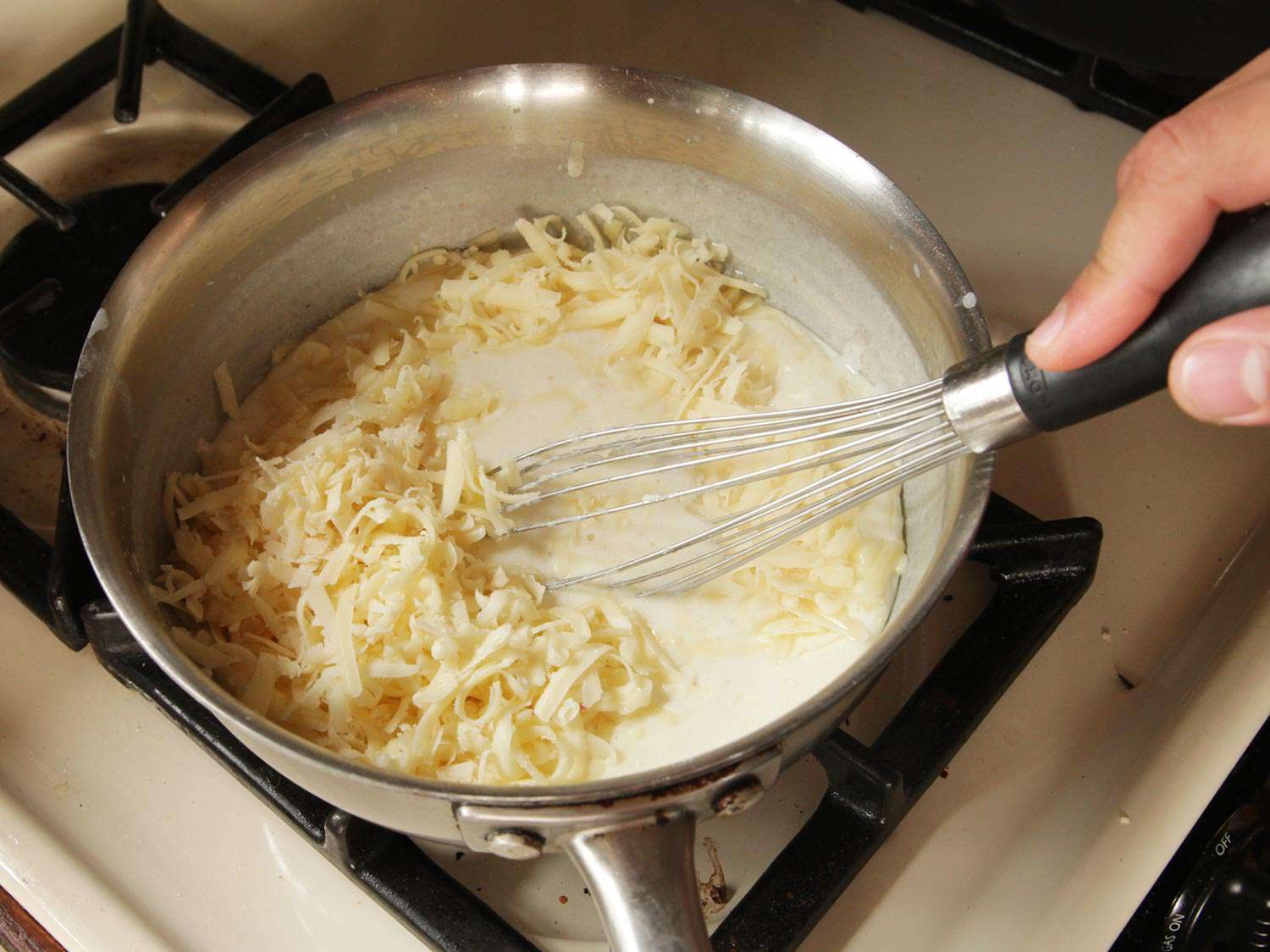 将格鲁耶尔奶酪放入白酱炖锅中搅拌。