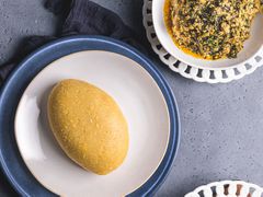 Eba plated next to a bowl of egusi soup