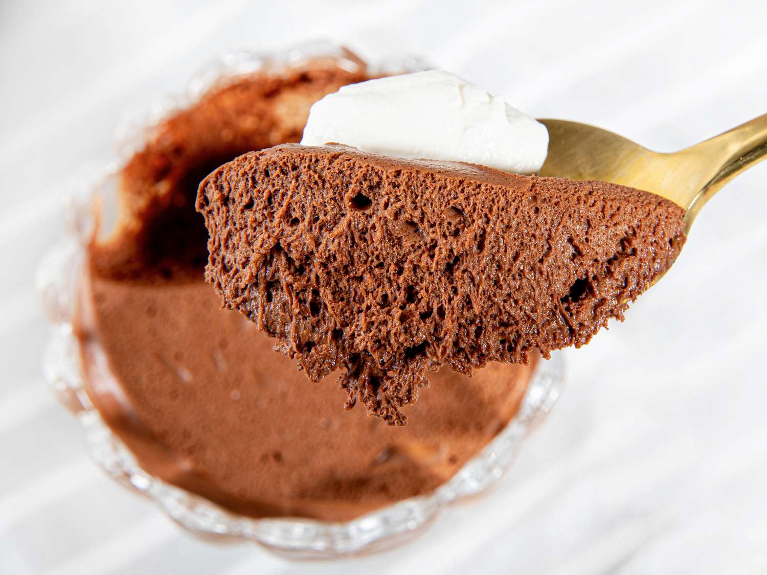 Side angle view of a spoon lifting up chocolate mousse